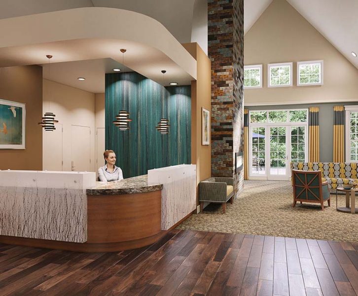 The lobby of a senior living community with a concierge sitting at the front desk