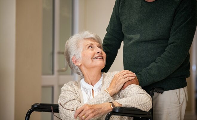 Senior man takes care of his old wife in a wheelchair