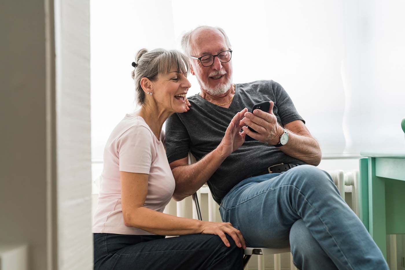 Senior Couple Using A Phone At Home