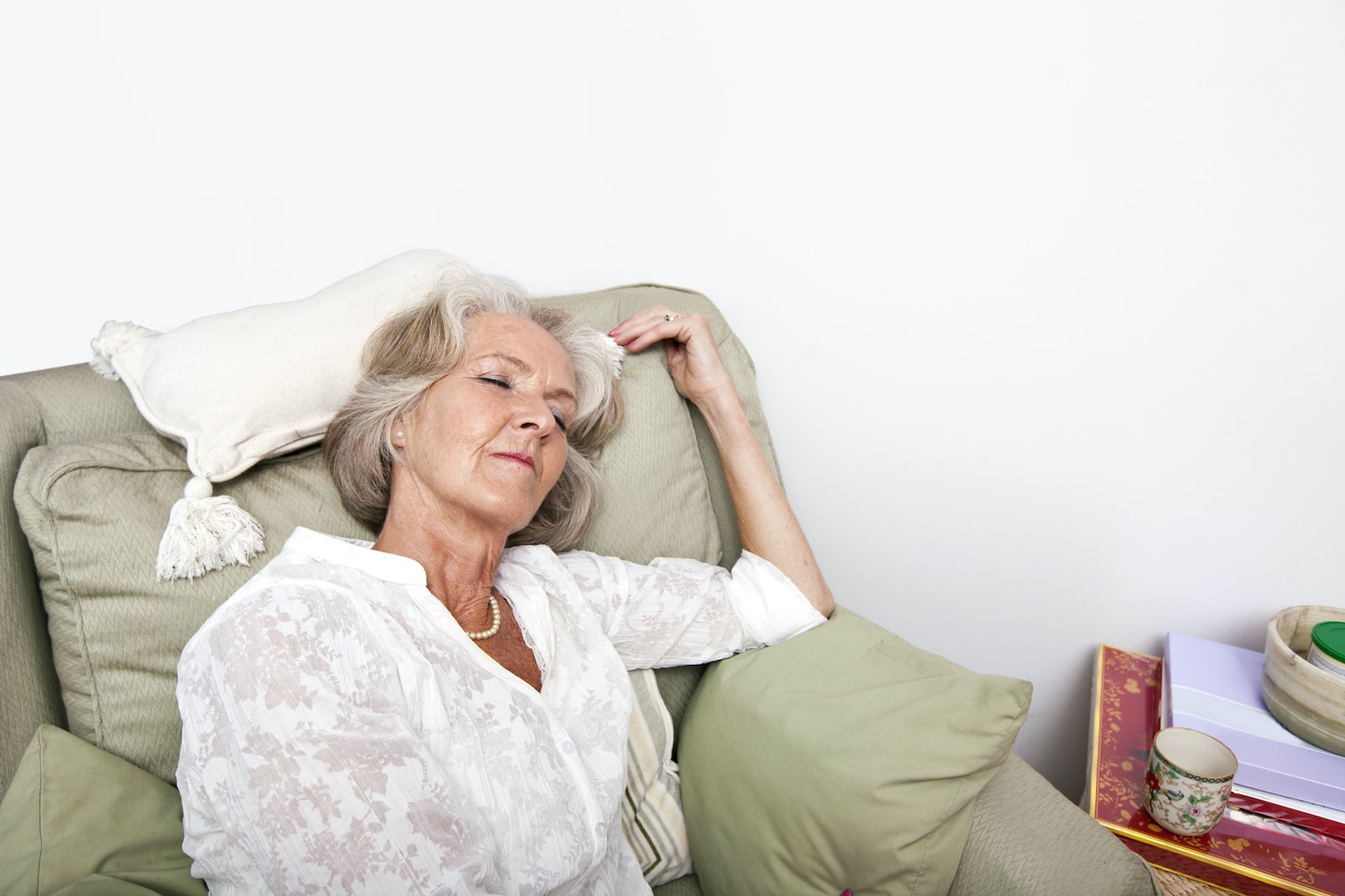 Tired senior woman sleeping on an armchair.