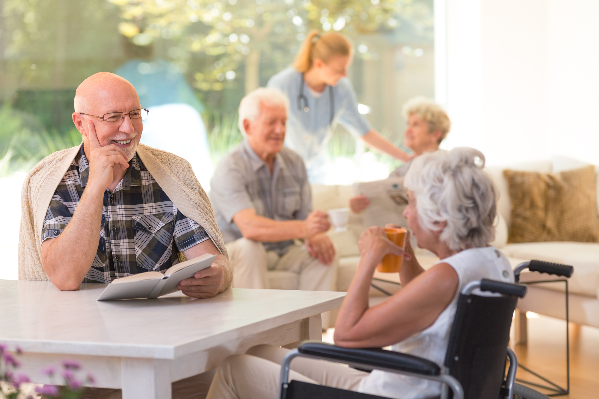 Happy seniors sitting in a group discussing a book.