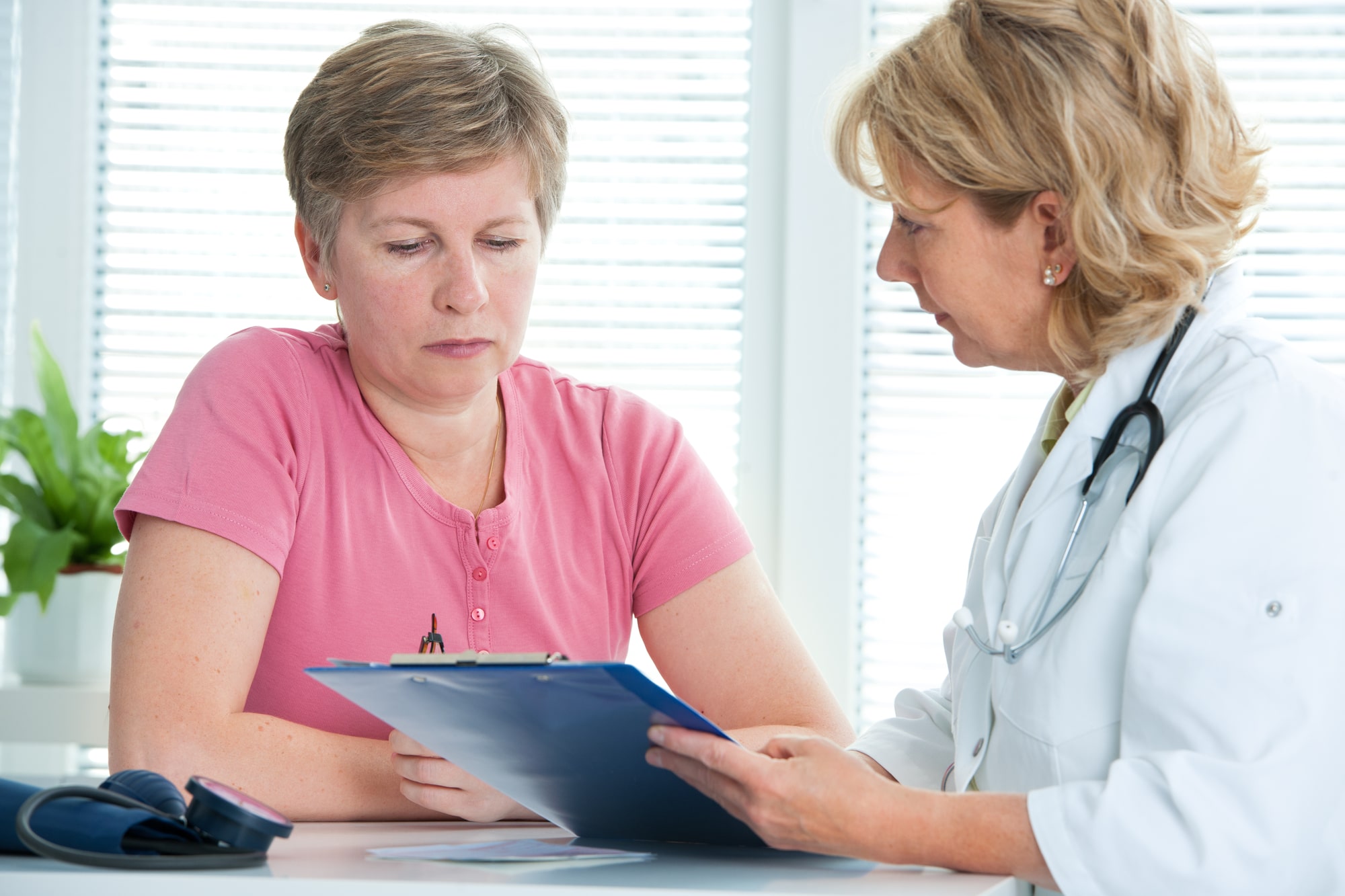 Image of a senior woman sitting with a doctor getting a medical evaluation.
