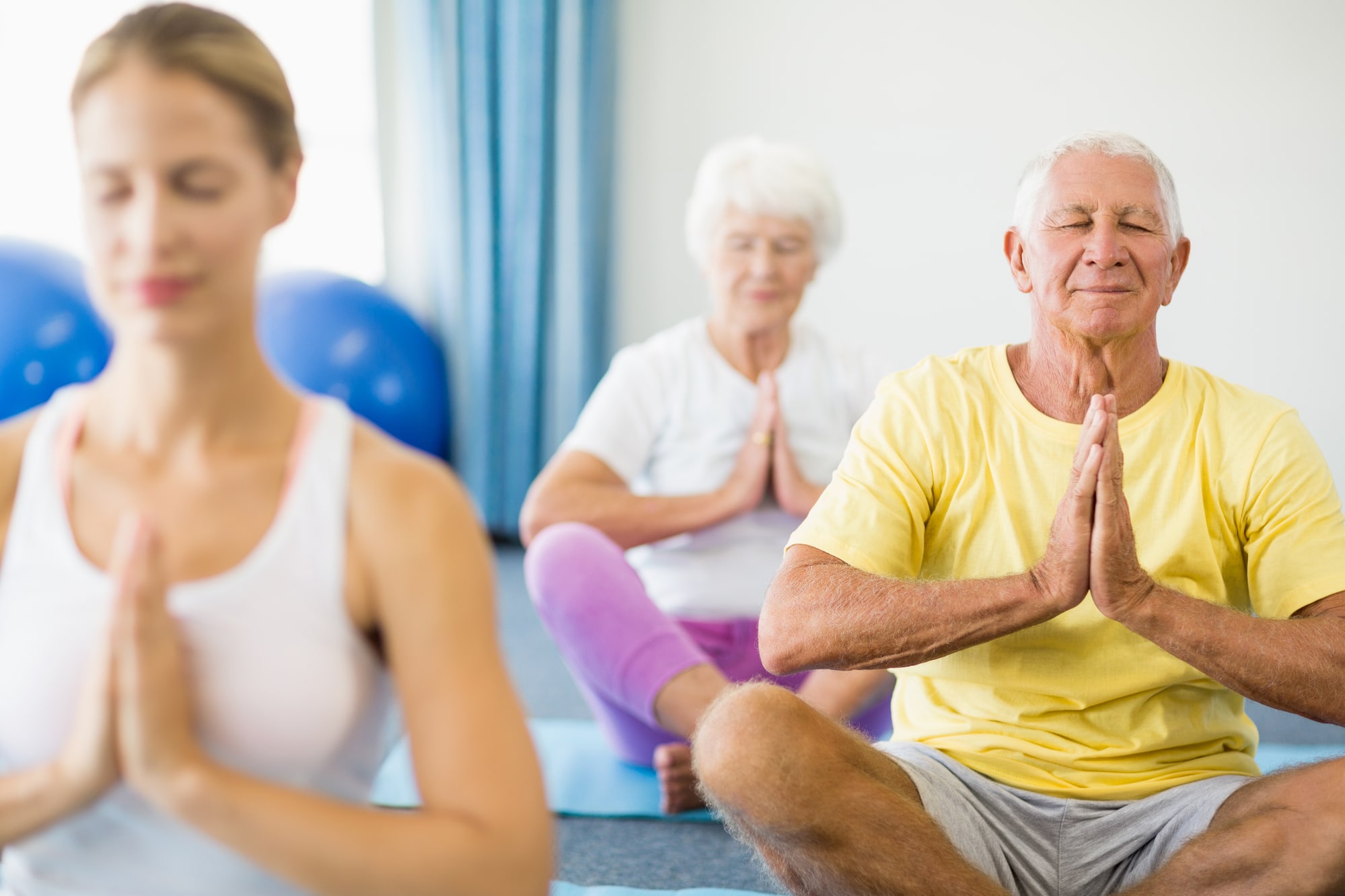 Image of a group of seniors meditating during a yoga class.