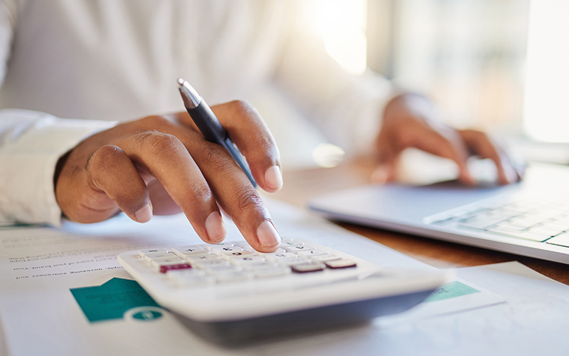 Close-up of a person's hand crunching numbers on a calculator