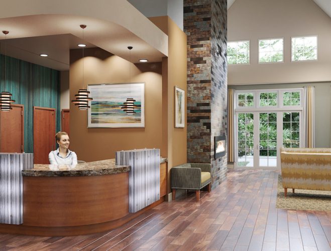 View of the entrance to a senior living community with a front desk attendant